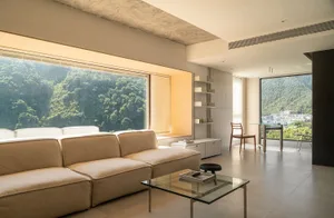 Modern living room with concrete walls, floor, and furniture.