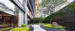 A modern urban garden featuring an artificial hedge wall.