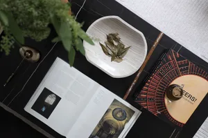 A minimalist coffee table setting with marble surface and decorative elements.