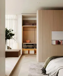 A modern minimalist bedroom featuring a wooden floating bed frame and a large wardrobe with integrated lighting.