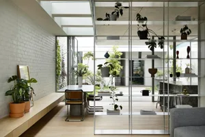 Industrial-style living space featuring exposed concrete walls and shelves filled with plants and decorative objects.