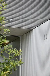 Modern house exterior featuring metal cladding and concrete materials