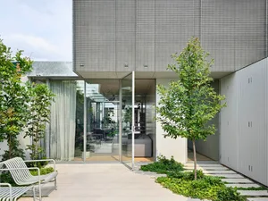 Minimalist residential architecture featuring a modern design with metal, glass, and concrete elements.