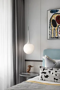 Modern bedroom interior with light fixture, textile bedding, and abstract artwork