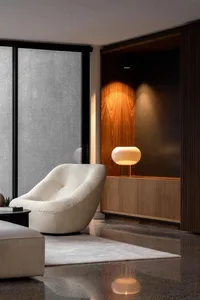 Contemporary minimalist living room with modern furniture and illuminated floor lamp.