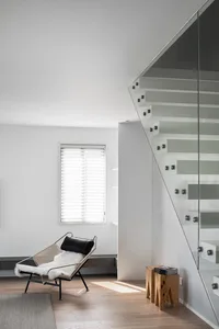 Modern interior featuring a glass and steel staircase.