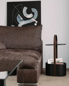 A modern living room featuring a fabric sofa, abstract artwork, and a side table.