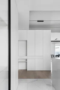 A modern, minimalist residential setting featuring white cabinets.