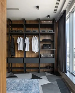 A modern closet with metal shelves featuring black and white clothing and accessories.