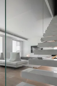 Modern living room with concrete stairs and minimalist furniture.