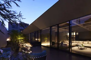 Modern living room featuring glass walls and concrete floors
