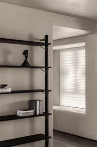 Minimalist black wooden shelf featuring books and decorative items.