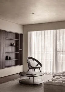 Modern living room featuring wooden shelves, a leather chair, and a cotton-cushioned sofa, with a round wooden coffee table.