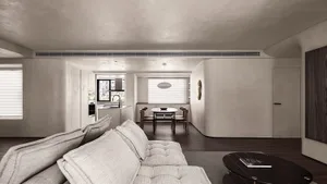 A minimalist living room and kitchen with concrete walls and wooden furniture.