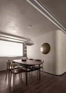 A modern dining room featuring wooden flooring, a wooden dining table with black legs, wooden chairs with brown cushions, a r