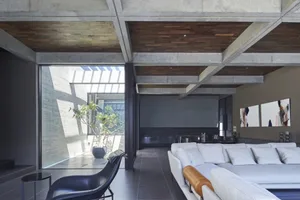 A modern living room featuring concrete and wooden elements.