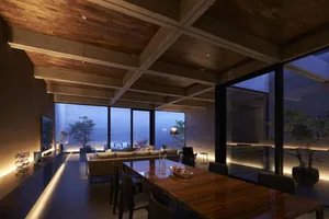 A modern residential interior with wood ceiling beams, glass walls, and concrete flooring.