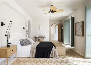 A minimalist bedroom with neutral-toned furniture and decor.