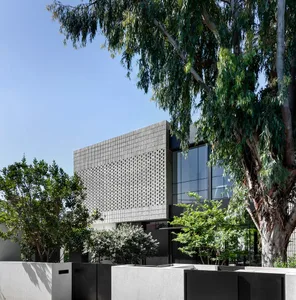 A modern house featuring glass walls in a peaceful outdoor setting.