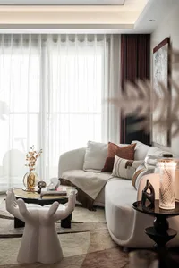 Modern living room with a white couch, geometric coffee tables, and neutral-toned decor.