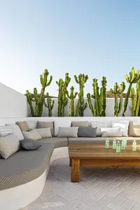 Outdoor seating area with wooden table, metal accents, and greenery.