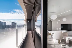 Modern minimalist apartment interior featuring glass, concrete, and metal materials.