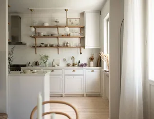 A minimalist kitchen featuring white subway tiles and wooden cabinets.