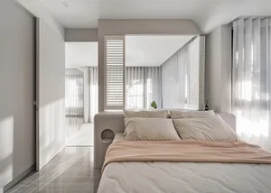 Modern bedroom with neutral tones and natural light.