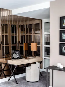 A modern home office featuring a sleek desk, round chair, and decorative elements.