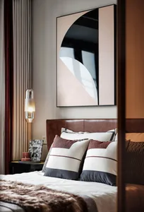 A modern bedroom featuring a leather headboard bed with geometric pillows and a pendant light hanging nearby.