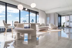 Modern living room featuring a light gray marble floor, minimalist furniture, and large windows with a cityscape view.