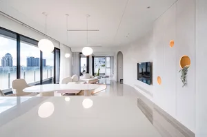 Modern living room with minimalist design, white walls, and large windows overlooking a cityscape.