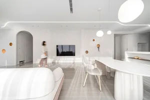 Modern minimalist residential interior with concrete walls and flooring, featuring a living area with a sofa, television, and