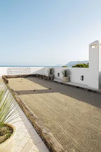 Outdoor residential space with a modern design, featuring a concrete floor and minimalist decor.