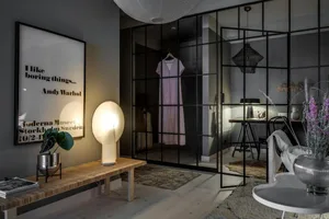 A modern interior design featuring a glass and metal framed closet with a clothing hanger.