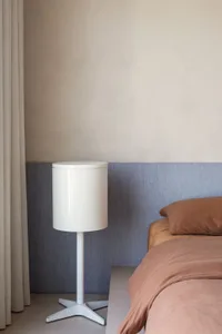 Modern minimalist bedroom with a bedside lamp, curtains, and soft lighting.
