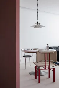 A minimalist dining setup featuring metal chairs with fabric cushions and a sleek table.