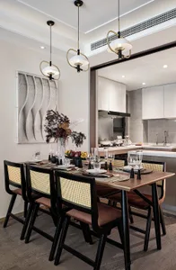 Modern dining area with a wooden table and chairs, featuring minimalist decor and sleek, contemporary design elements.