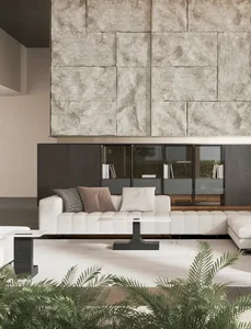 A modern living room with a white sectional sofa, concrete accent wall, and green plants.