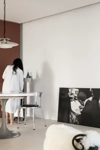 A modern living space with a minimalist design, featuring white walls, black accents, and a white ceramic floor with a black 