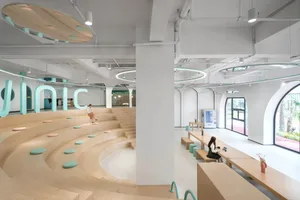 A modern coffee shop with a minimalist design, featuring wooden seating, circular light fixtures, and glass windows.