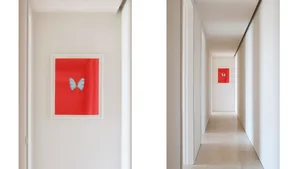A red framed glass artwork featuring a butterfly is mounted on a corridor wall.