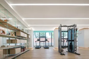 A minimalist fitness center with wooden flooring.
