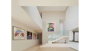 Modern interior design featuring a glass staircase with colorful artwork on the walls.