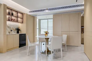 Modern kitchen and dining area with marble countertops and wooden cabinetry.