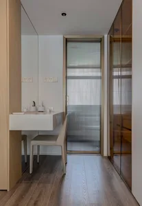 Modern minimalist home office with a white desk and gray chair featuring a minimalist design aesthetic and wooden flooring.