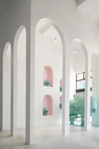 A modern museum exhibition featuring concrete walls and arches.