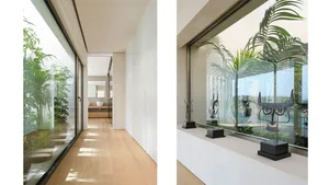 Modern residential interior featuring glass walls and wooden flooring.