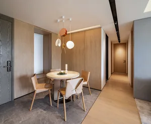 Modern minimalist dining area featuring a round table and chairs with wooden and marble components.