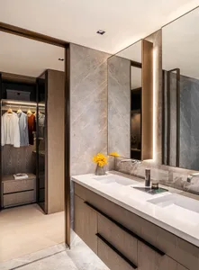 Modern bathroom with marble finishes, dual sinks, and a walk-in closet.